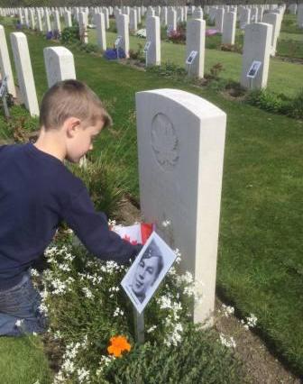 Child places flag by Alfreds grave